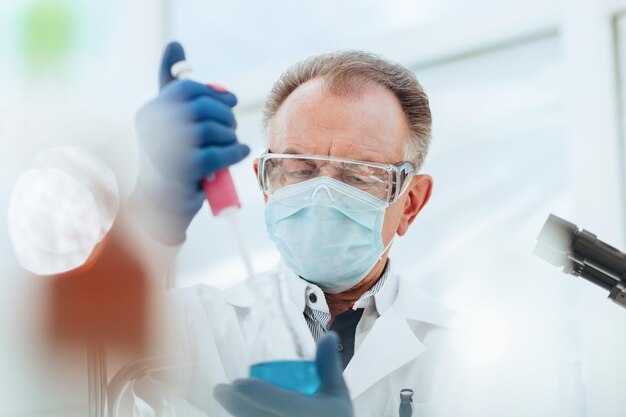 Close up researcher using an automatic dispenser in a medical laboratory