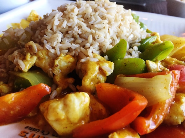 Close-up of rice on chicken curry served in plate