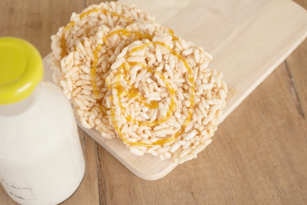 Close up rice crackers with Bottle glass of Milk on a wooden table. Rice crackers with Bottle glass of Milk.