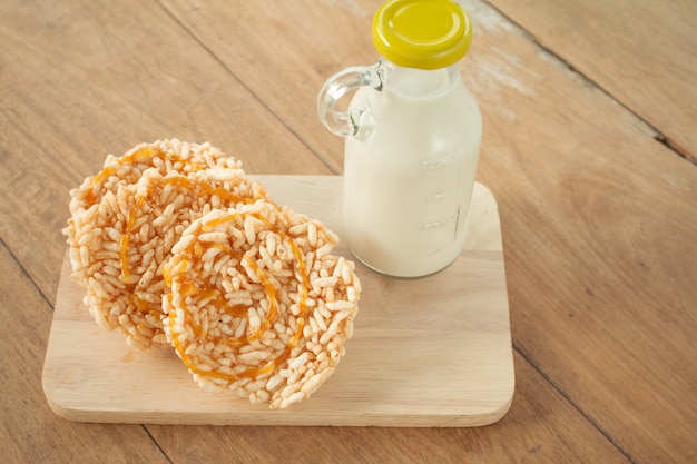 Close up rice crackers with Bottle glass of Milk on a wooden table. Rice crackers with Bottle glass of Milk.