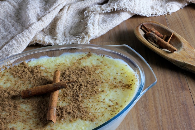 Close up rice pudding with cinnamon in glass container, contoured by fabric