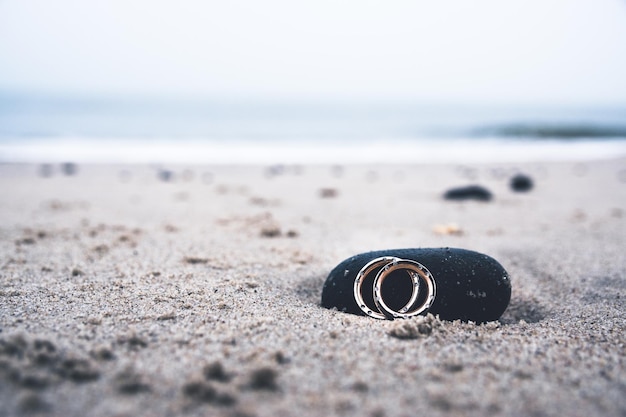 Close-up of ring and stone on sand