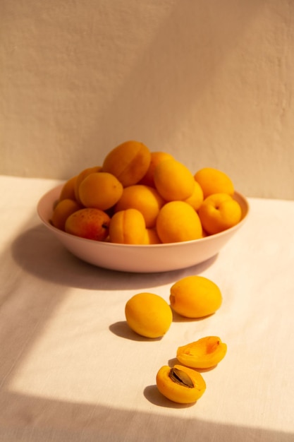 Close-up of ripe apricots in a plate on a light background