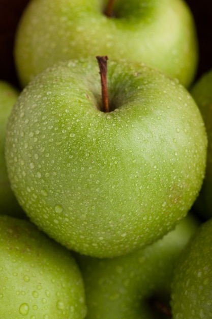 Foto close-up di mele verdi mature ricoperte di rugiada.