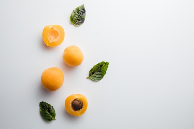 Крупным планом спелых персиков на столе с листьями