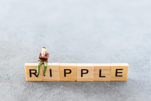 Close-up of ripple text and male figurine on table