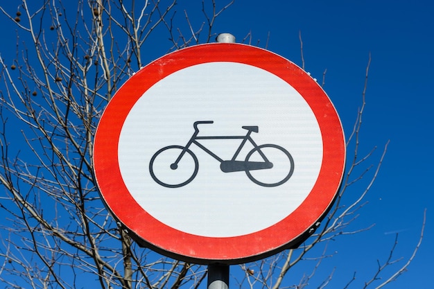 Close-up of road sign against blue sky