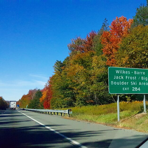 Photo close-up of road sign against clear blue sky