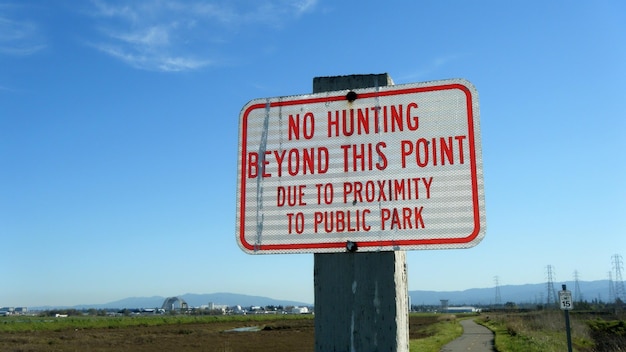 Close-up of road sign against clear blue sky