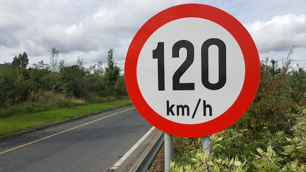 Close-up of road sign against cloudy sky