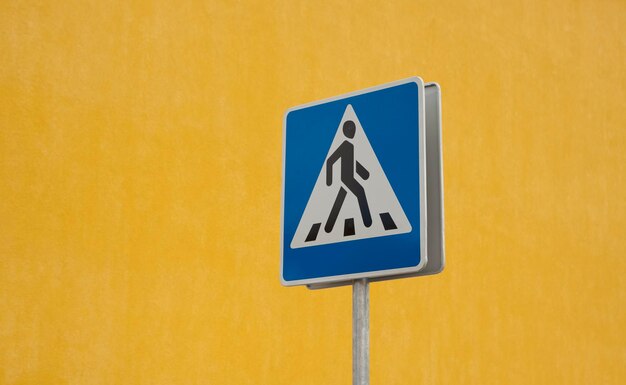 Photo close-up of road sign against yellow wall