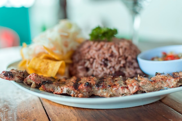 Close up of roast beef with gallo pinto and pico de gallo Plate with roast beef and rice