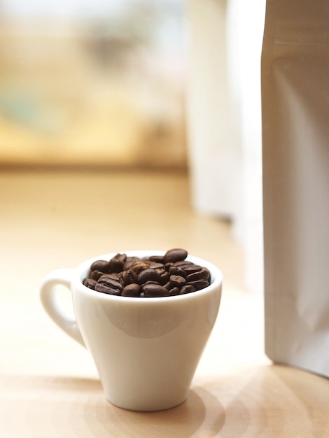 Close up roasted coffee bean in white cup