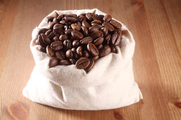 Photo close-up of roasted coffee beans in sack on table