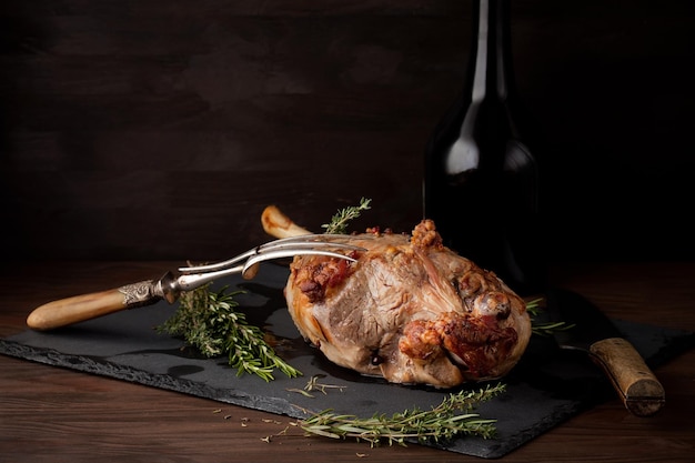 Photo close-up of roasted meat and fork on granite