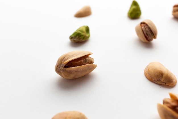 Close up of roasted pistachios isolated on white background