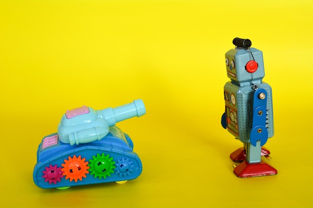 Photo close-up of robot and armored tank toys on yellow background