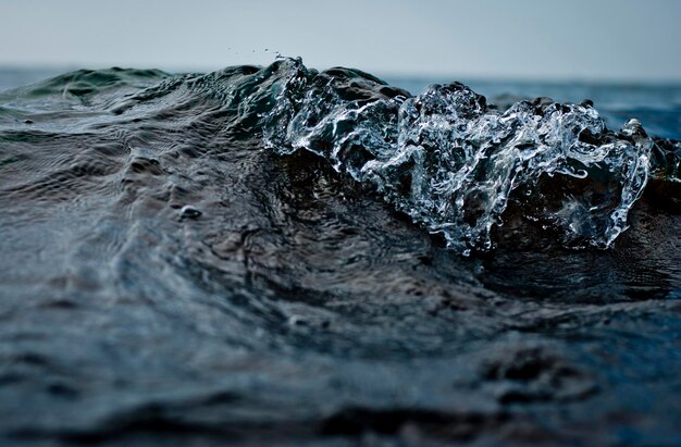 Photo close-up of rocks in sea against sky