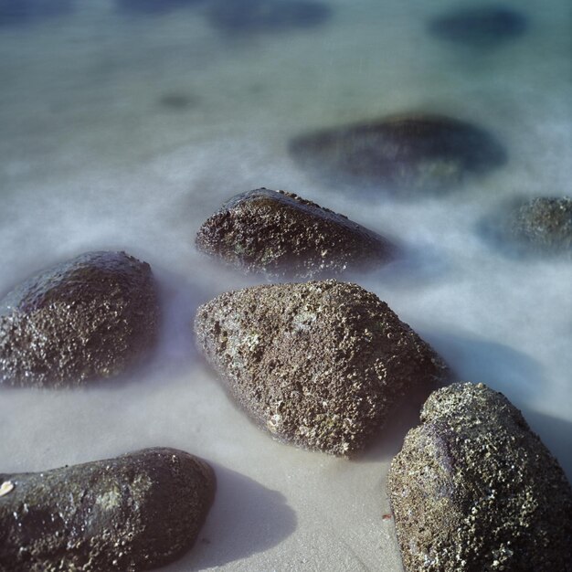 Photo close-up of rocks on shore against sky