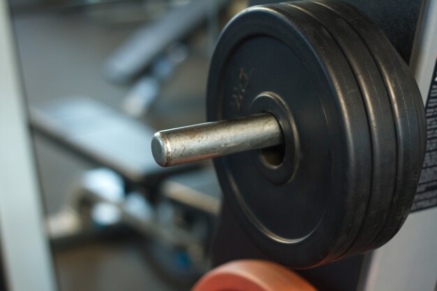 Foto primo piano di una canna con pesi in palestra, sfondo o concetto di sollevamento pesi e sport