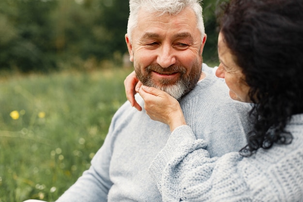 Close up romantic couple sitting in autumn park  and hugging in daytime