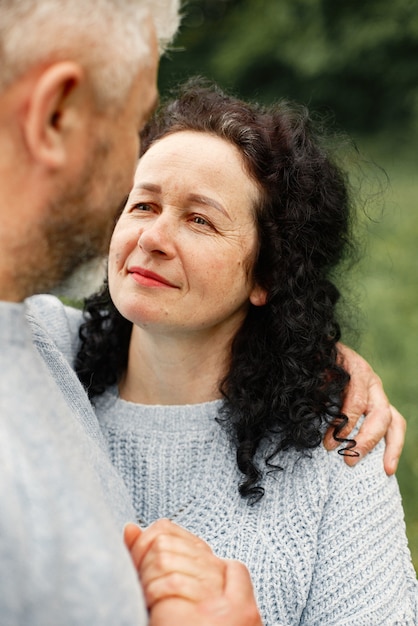 Close up romantic couple standing in autumn park  and hugging in daytime