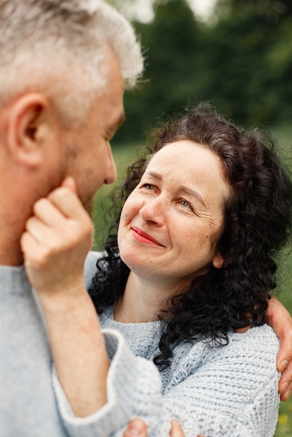 Close up romantic couple standing in autumn park  and hugging in daytime