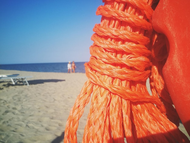 Клоуз-ап веревки на пляже на фоне ясного неба