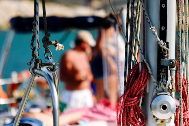 Close-up of rope in boat with man standing in background