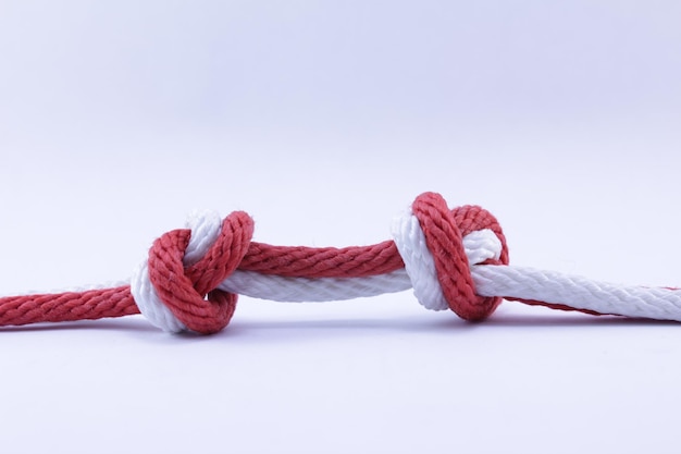 Photo close-up of rope tied on metal against white background
