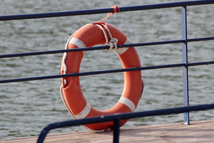Photo close-up of rope tied to railing against sea