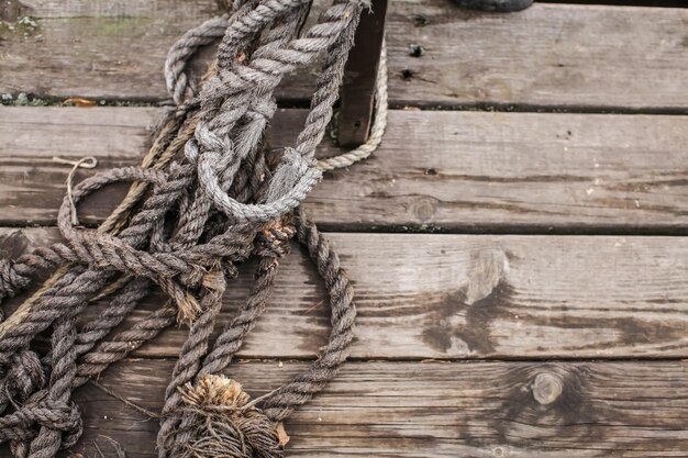 Photo close-up of rope tied to wooden pier