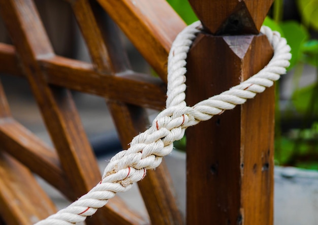 Foto close-up di una corda legata a un palo di legno.