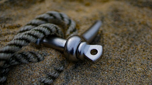 Close-up of rope with metal in sand