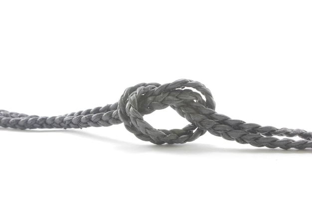 Photo close-up of rope with tied knot over white background