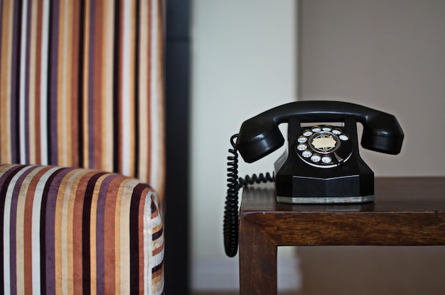 Photo close-up of rotary phone on table at home