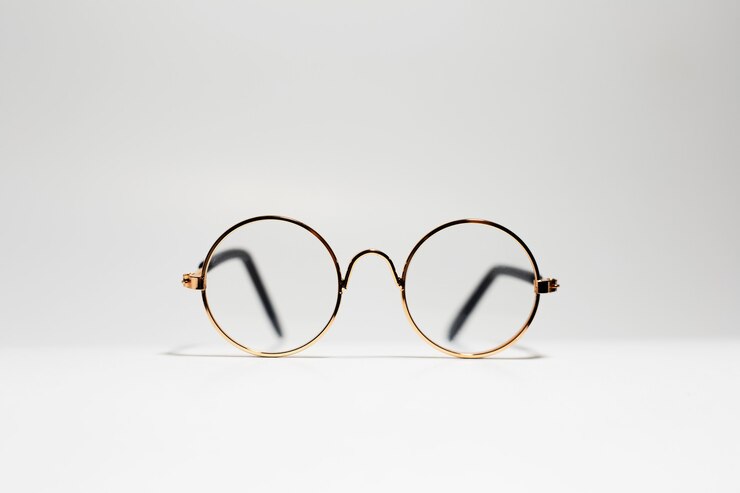 Close-up of round gold eyeglasses isolated on white