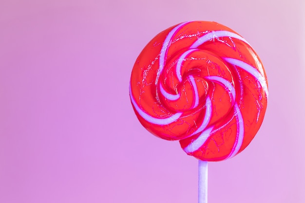 Close-up round lollipop in trendy neon light.