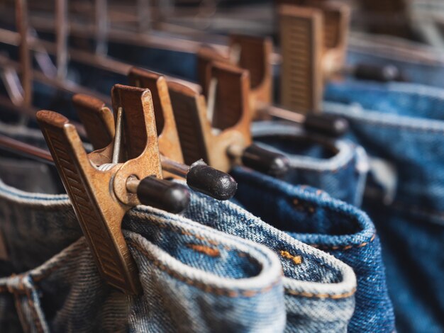 Close up row of many blue jeans are hanging in the shop