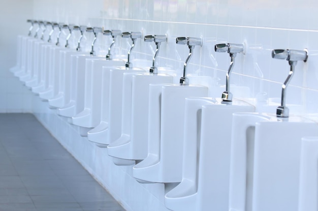 Close up row of outdoor urinals men public toilet.