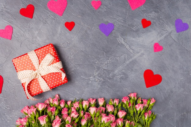 Close-up Roze spray rozen geschenk in rode doos op grijze achtergrond Vrouwendag Moederdag Valentijnsdag concept Kopieer de ruimte