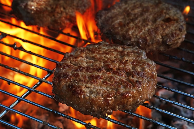 Close-up rundvlees of varkensvlees barbecue hamburgers voor hamburger bereid gegrild op bbq vuur vlam grill, hoge hoek weergave