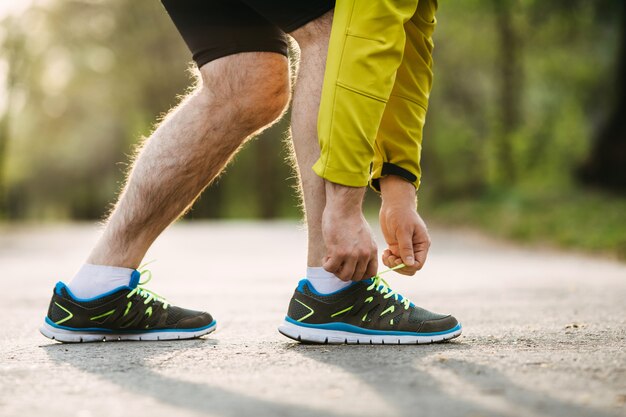 Close-up of runner tying shoelaces on sneakers