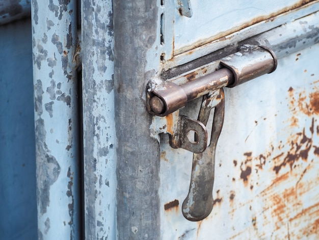 Close up of rusted keyhole on blue steel door