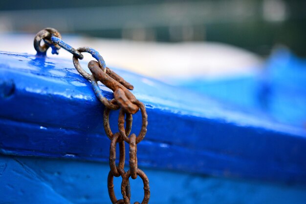 Close-up of rusty chain on blue boat