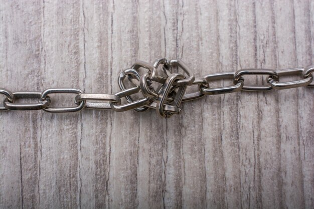 Close-up of rusty chain on wooden fence