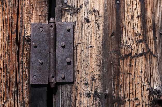 Close-up rusty metal loop nailed to old wooden door.