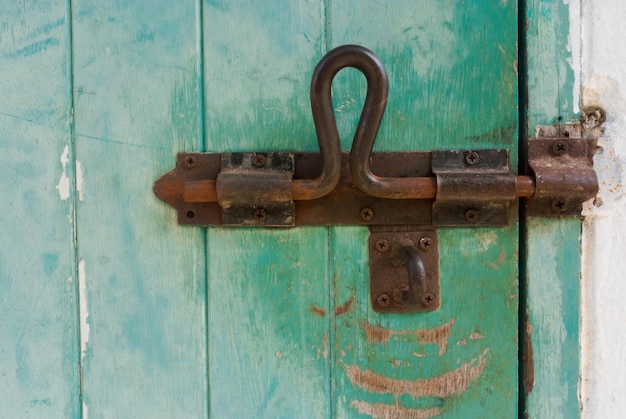 Photo close-up of rusty metallic latch on door