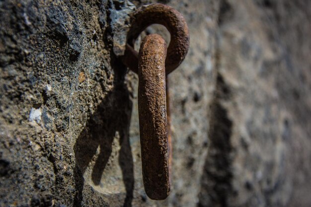 Foto close-up di un anello metallico arrugginito montato su un muro di cemento