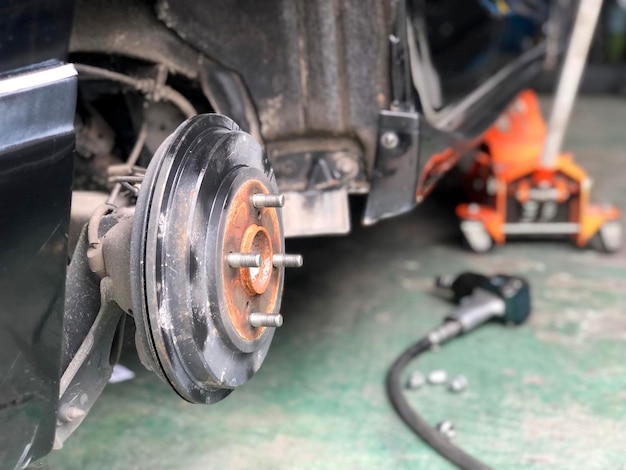 Foto prossimo piano di una parte di un veicolo arrugginita in un'officina di riparazione auto